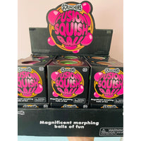 Scrunchems Fusion Squish Ball toy packaging display showing multiple black boxes with bright pink and yellow graphics, plus a larger sign above reading 'Scrunchems Fusion Squish Ball'.