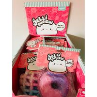 A box of Keycraft Jellі squishies, showing a pink display box filled with individually wrapped squishy toys, including a purple donut-shaped one in the foreground.