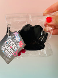 Back view of Black Scrunchems Sticky Squishy Paw Print fidget toy