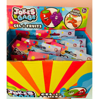 A retail display box filled with Jokes & Gags Gel-i-Fruits blind bag packs. The packaging features bright, colorful graphics with cartoon fruit characters and a yellow and red sunburst pattern on the front.