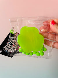 Back view of Green and Orange Scrunchems Sticky Squishy Paw Print sensory toy